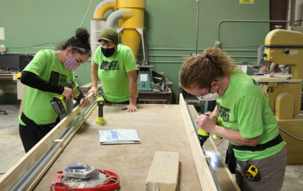 Trailblazers in Rutland use cordless drills to screw wood while the instructor looks on.