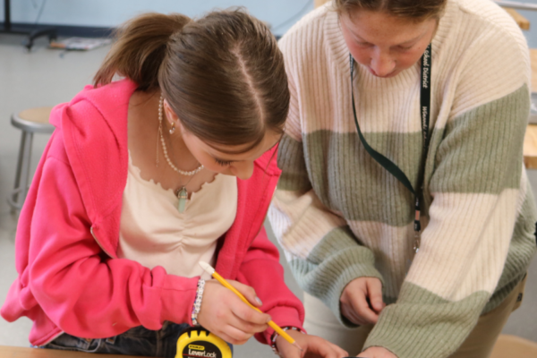 Middle school student uses a measuring tape at Rosie's Girls Afterschool