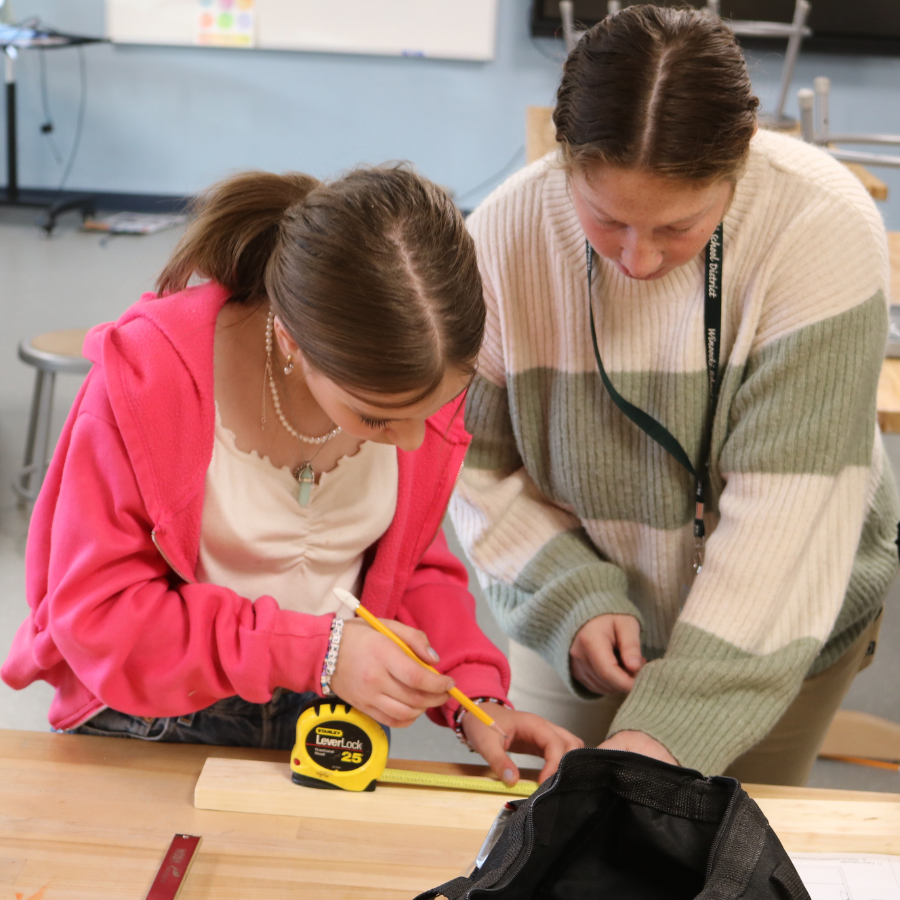 Middle school student uses a measuring tape at Rosie's Girls Afterschool