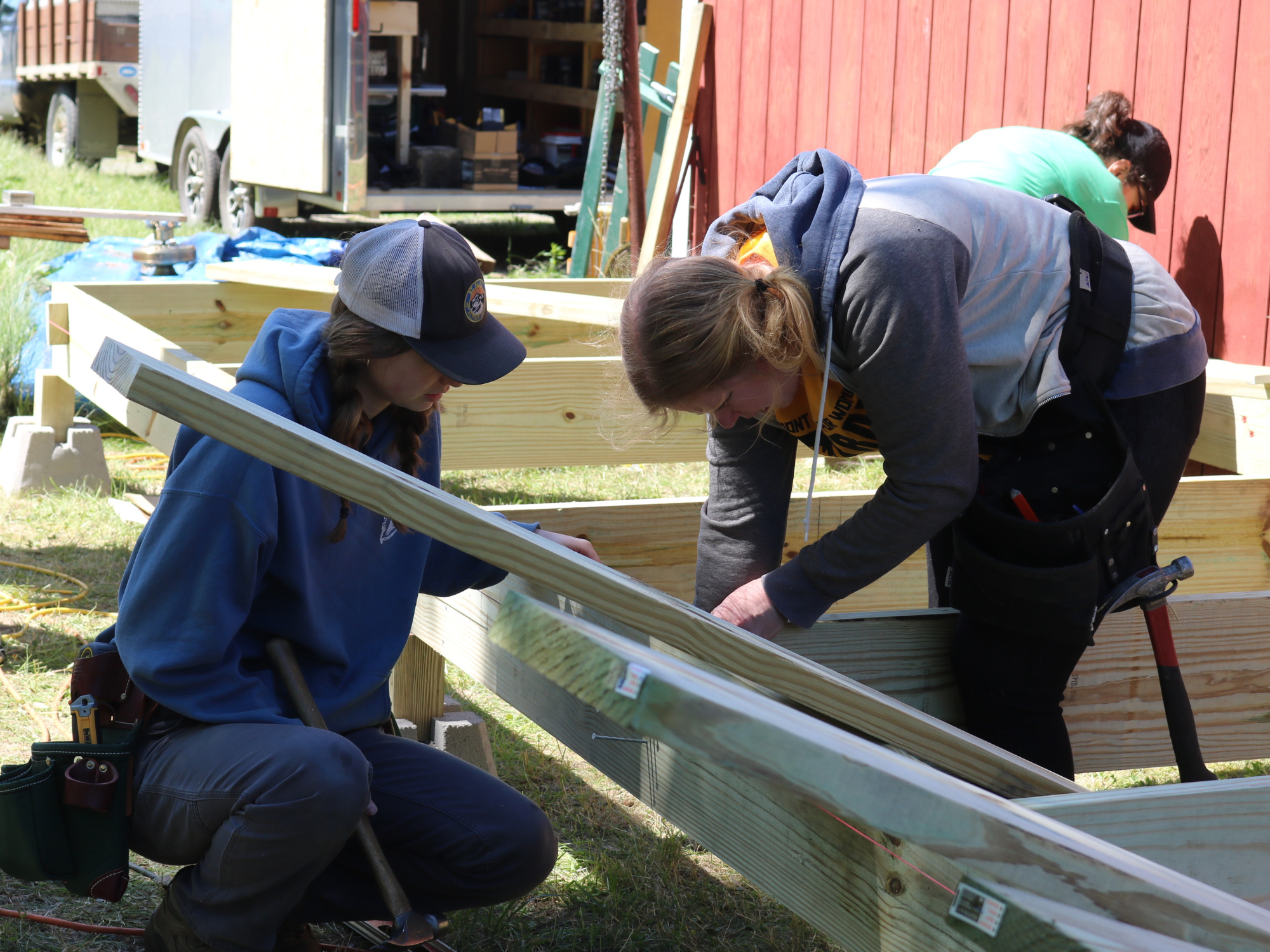 Two Trailblazers build a small deck during the trades training class.