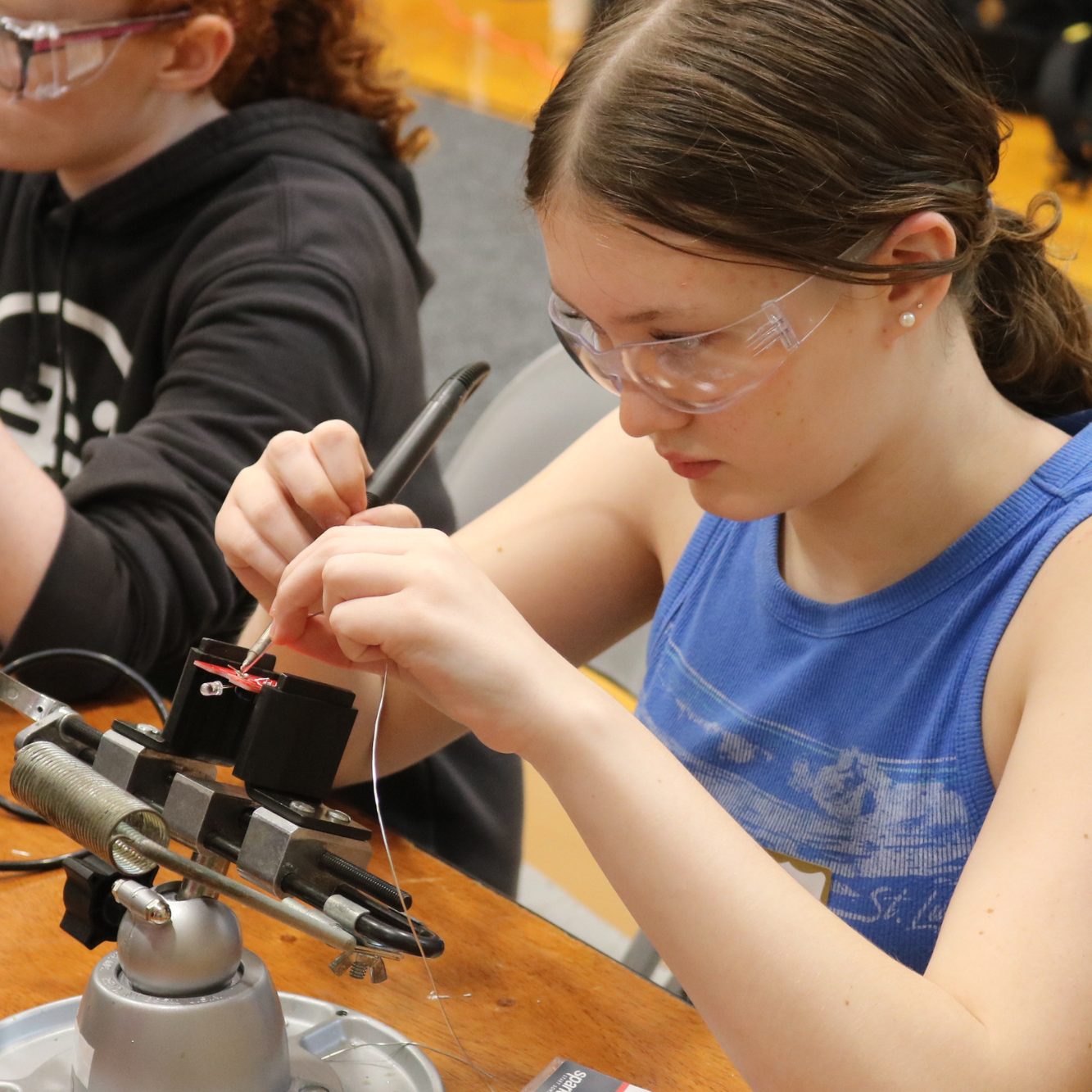 A high school girls tries soldering at the Women Can Do career exploration conference