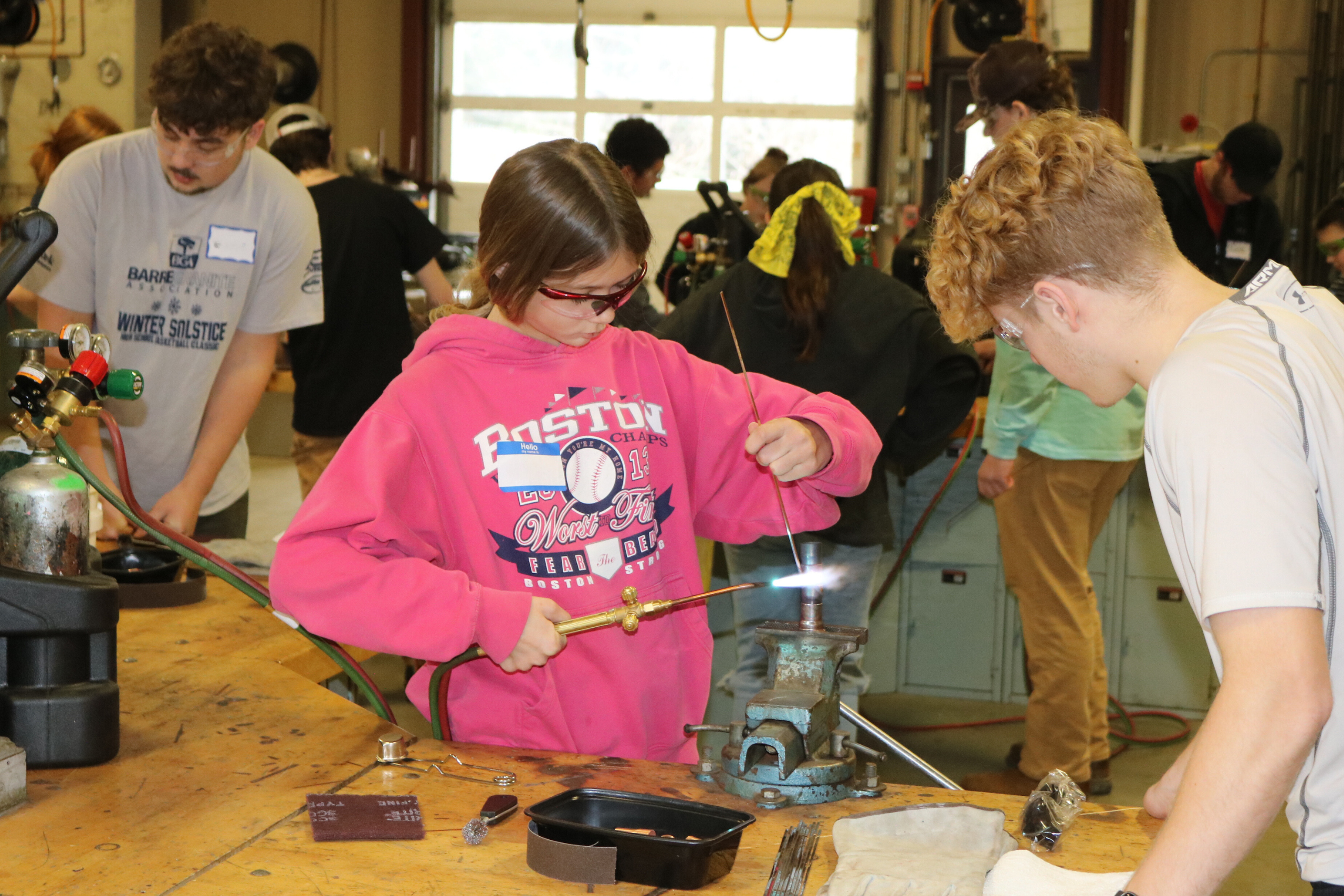 Middle school girl brazes copper pipes at Career Challenge day at GMTCC.