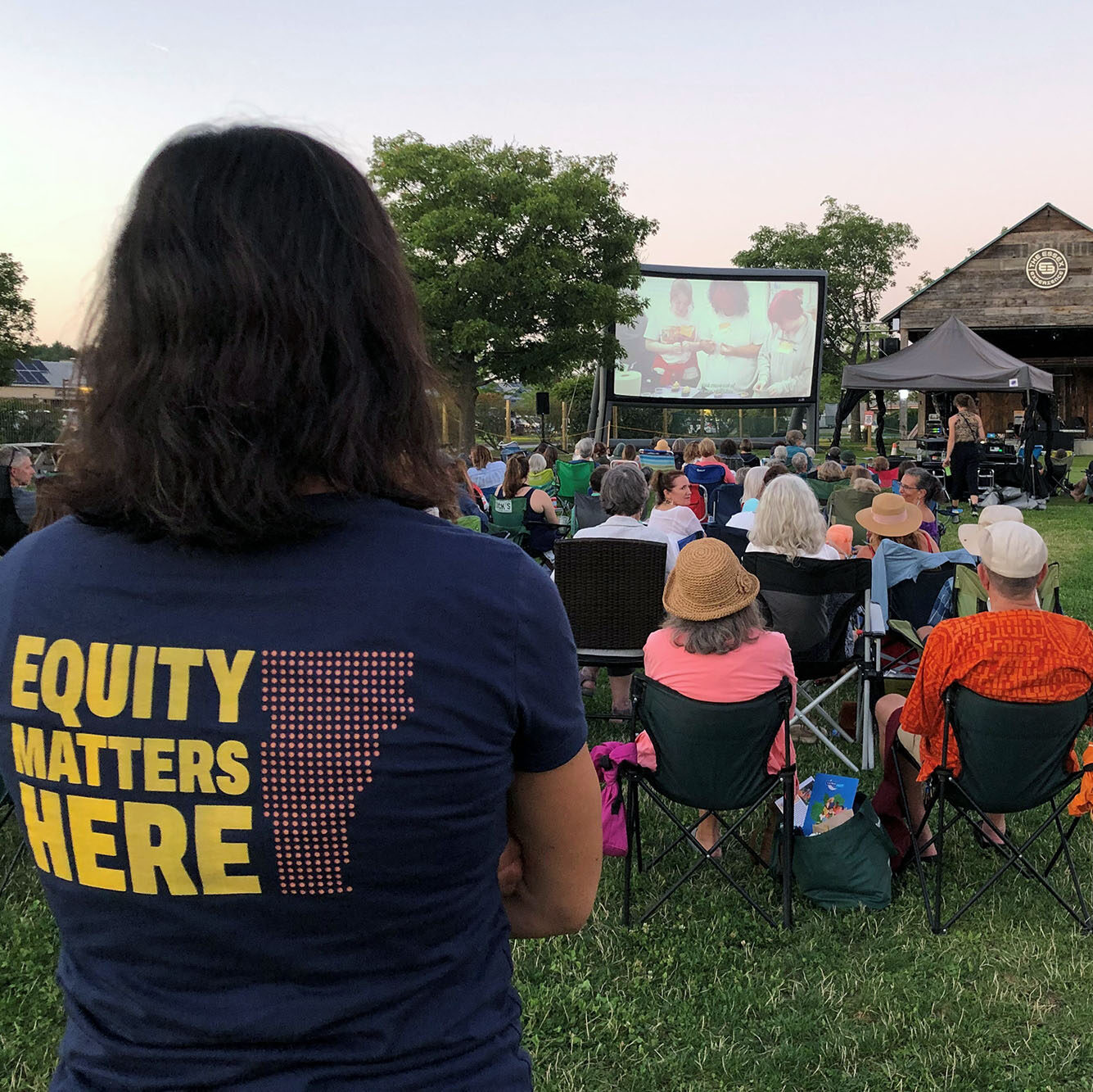 Vermont Works for Women staff member watches LUNAFEST films on the Green at Essex Experience. Community members can get involved with our mission by attending events like these.