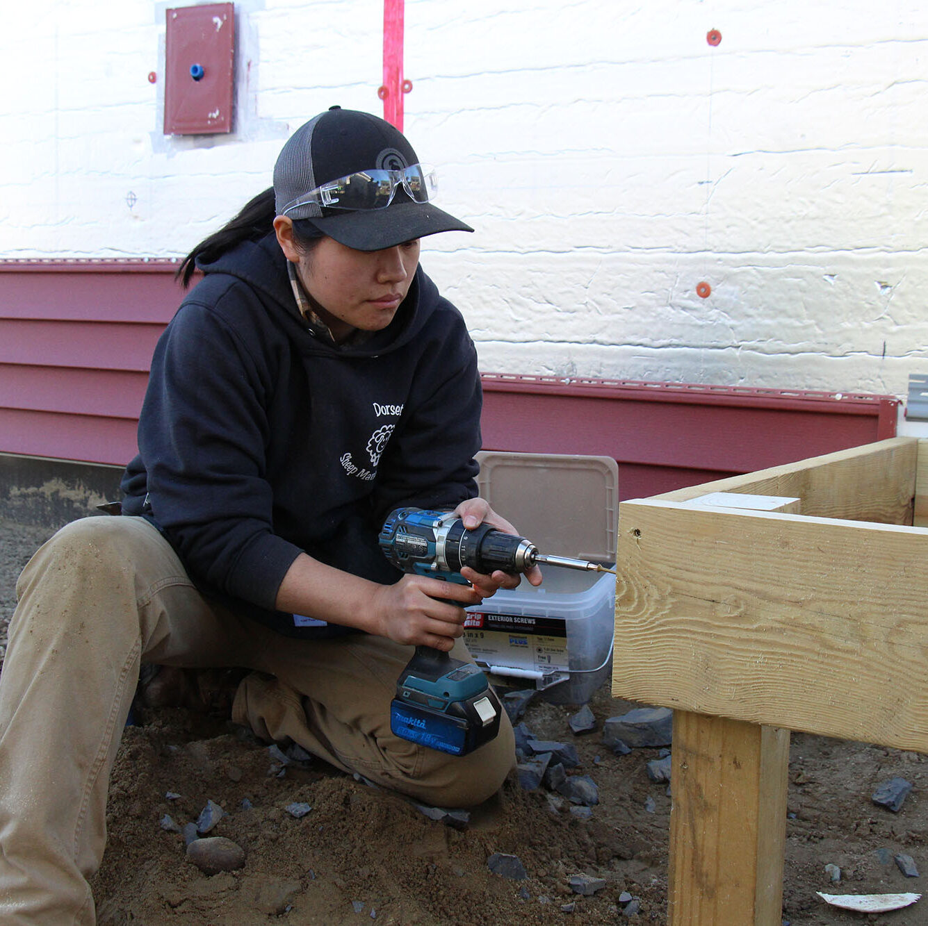 A Trailblazers participant uses a drill to build a back porch.