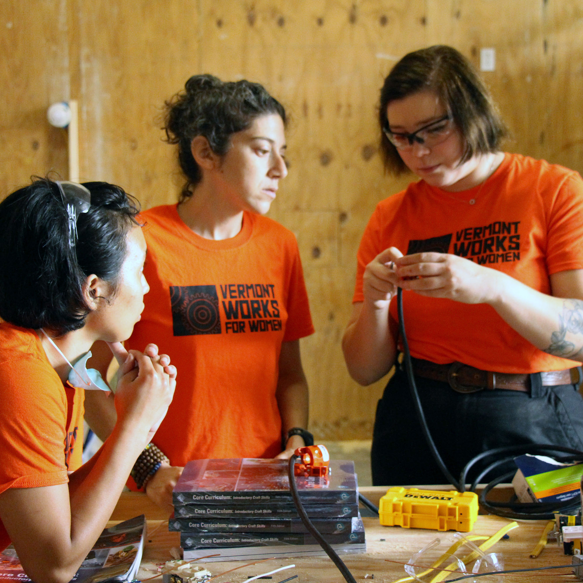Trailblazers examine wire together in the shop. Trailblazers is founded in Vermont Works for Women's history of being a trades training organization.