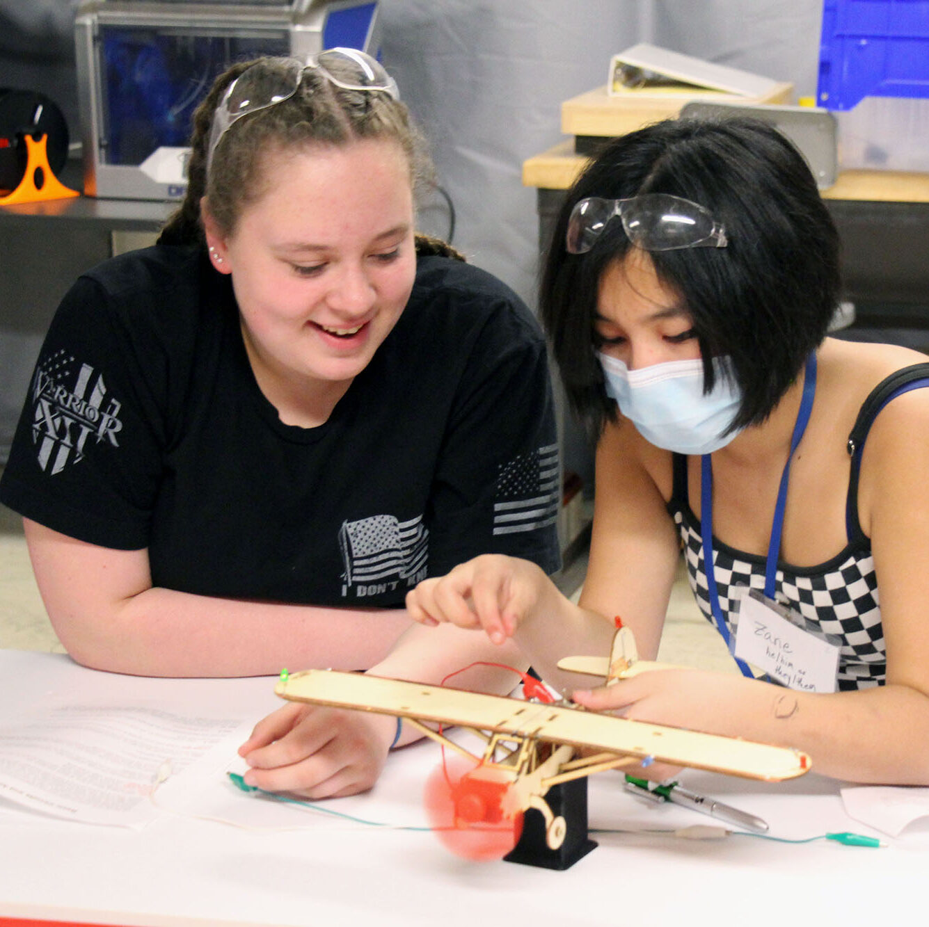 Middle school girls use wires and circuits to make a propeller run on a wooden model plane. Introducing girls to a variety of career opportunities is part of Vermont Works for Women's overall mission.