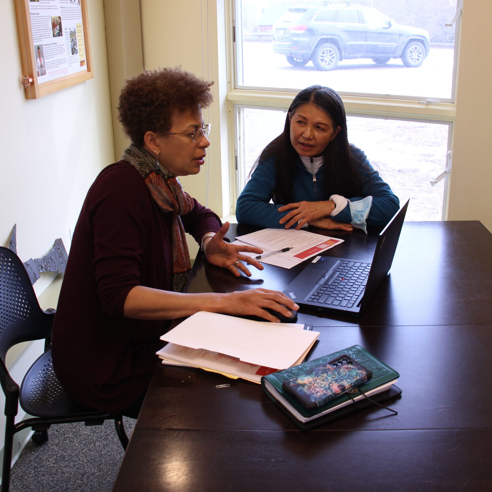 Vermont Works for Women's Employment and Career Services Manager sits down at a table with a participant.