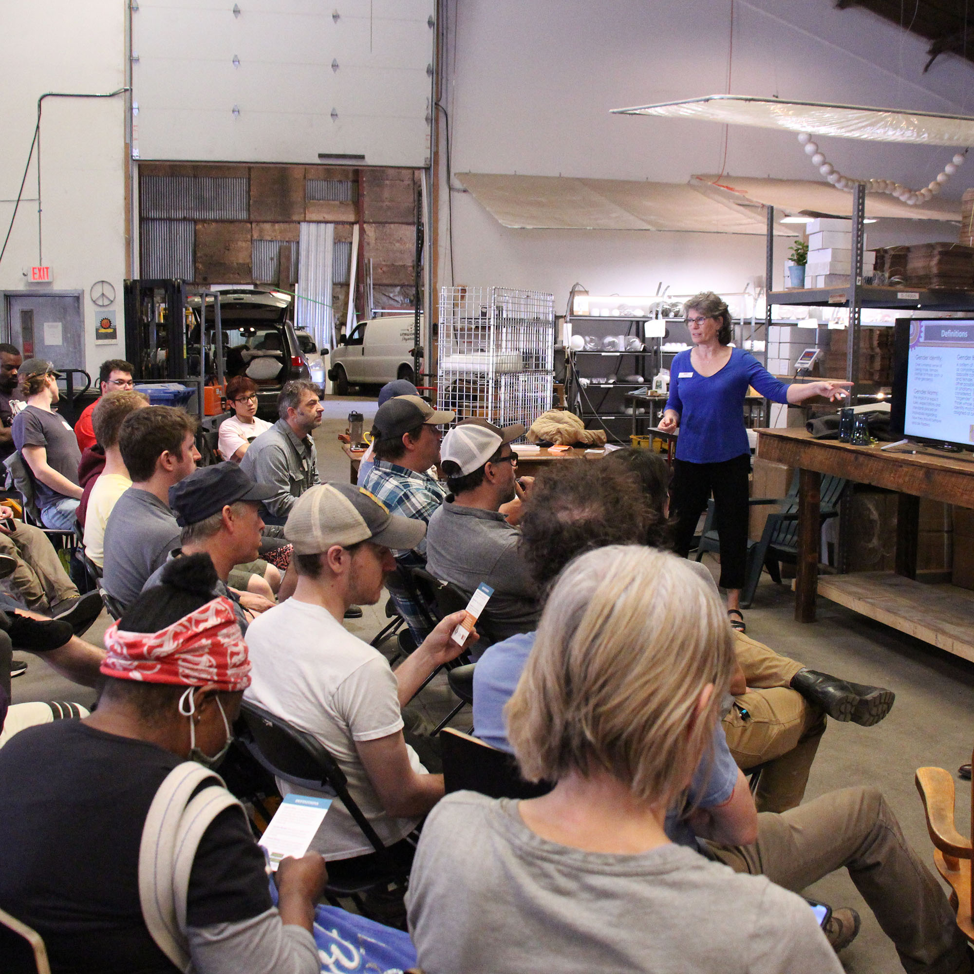 Vermont Works for Women Program Manager Missy Mackin speaks to dozens of employees at AO Glass.