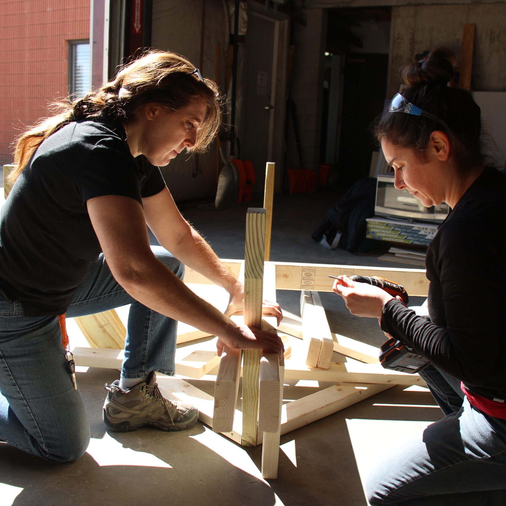 Two women work together to build a picnic table at Trailblazers, Vermont Works for Women's trades training program for women.