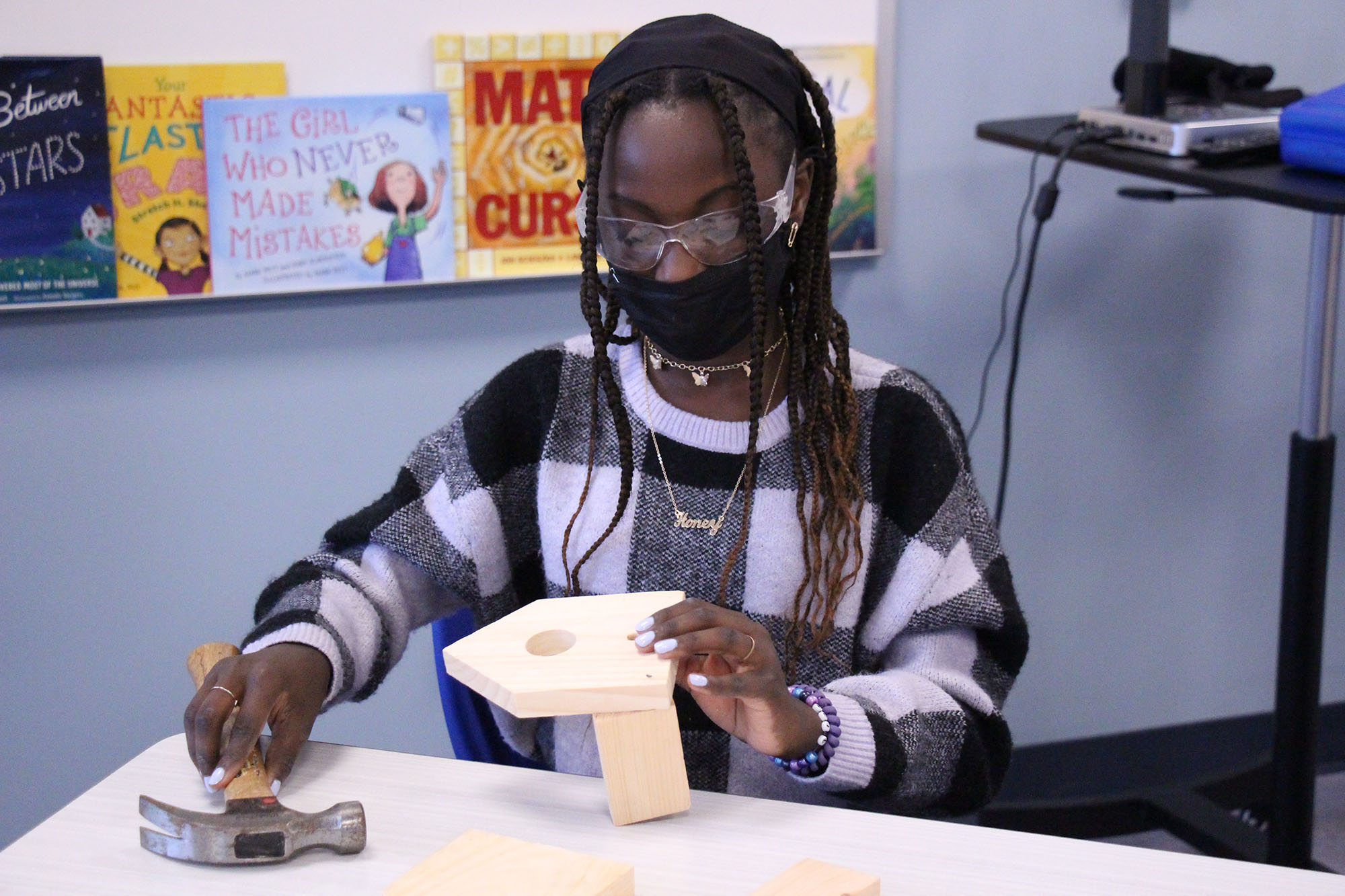 Student in Rosie’s Girls afterschool program uses hammer to build a birdhouse.