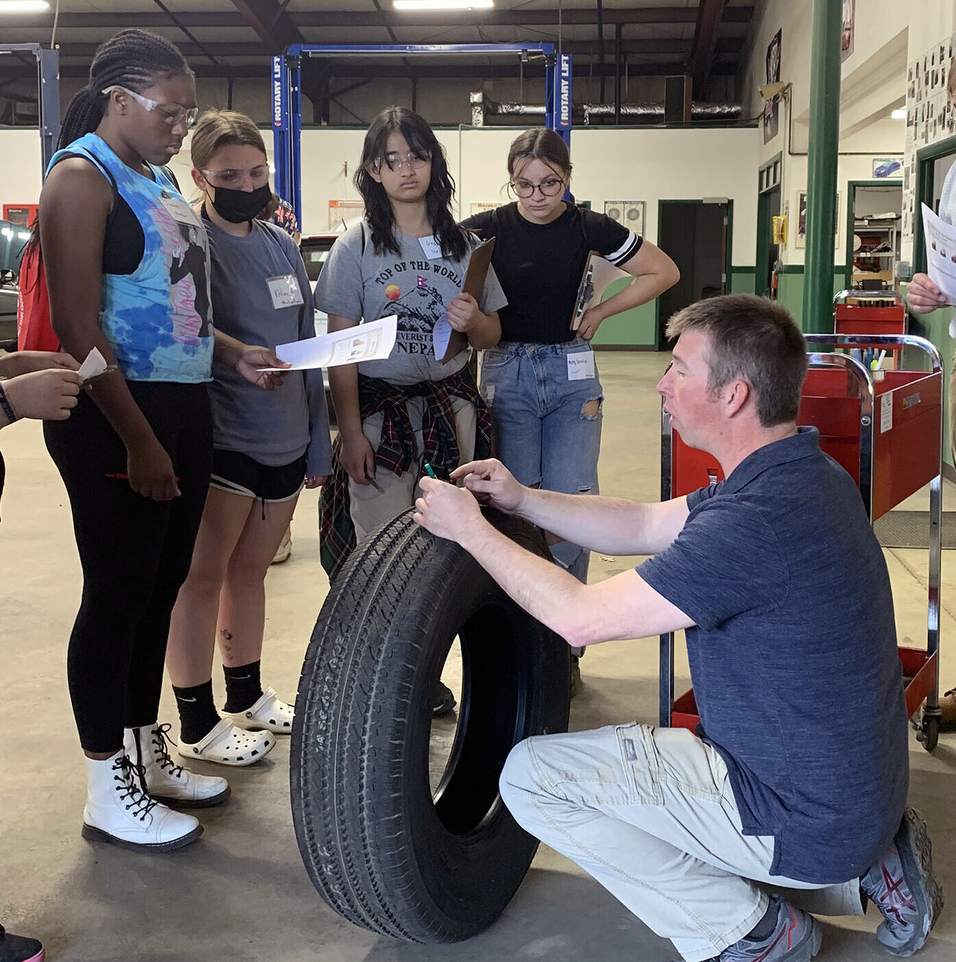 An auto instructor shows middle scshool students how to test their tire's grip at Career Challenge Day.