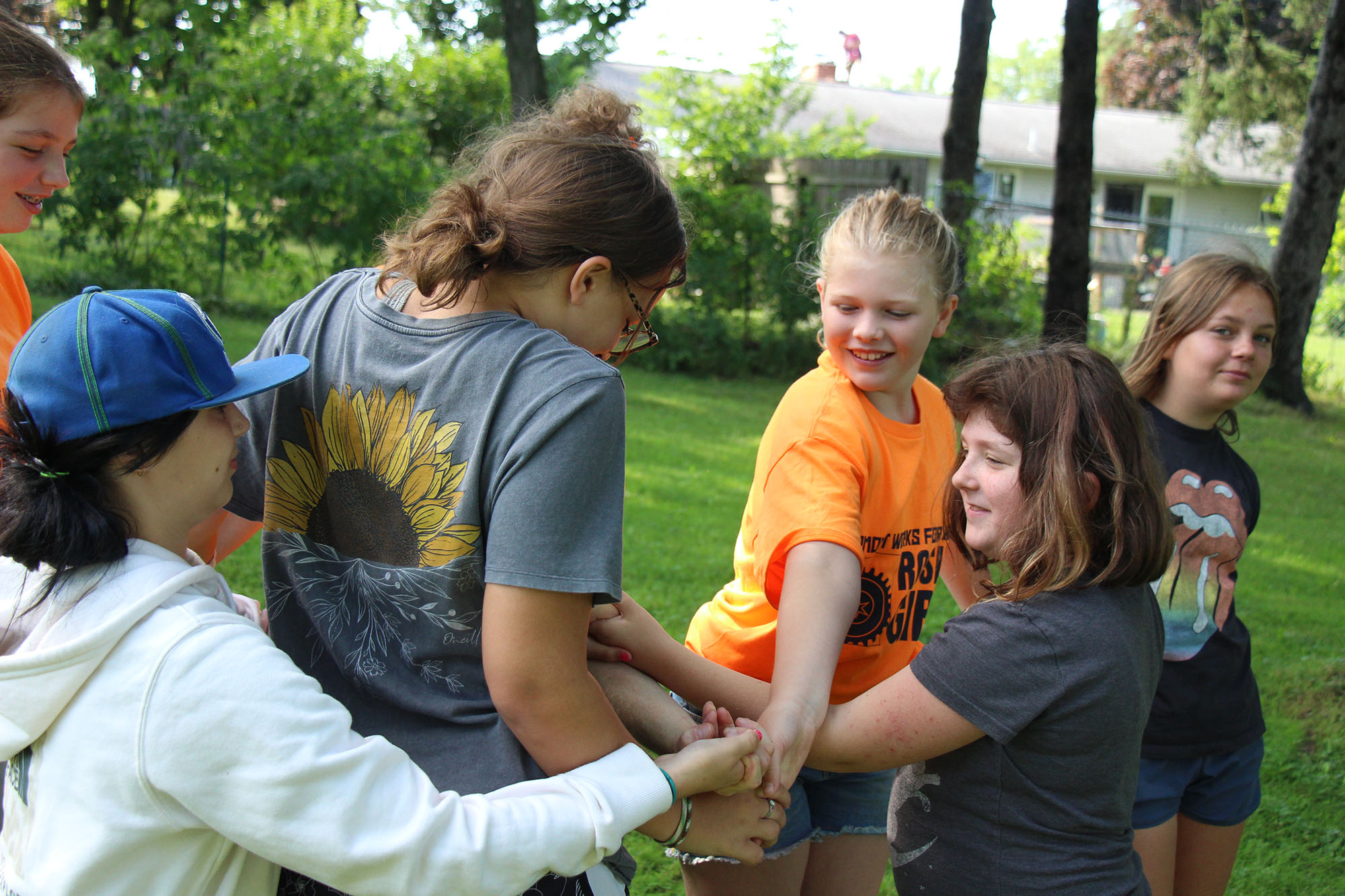 Rosie's Girls campers work on untying themselves from a human pretzel.