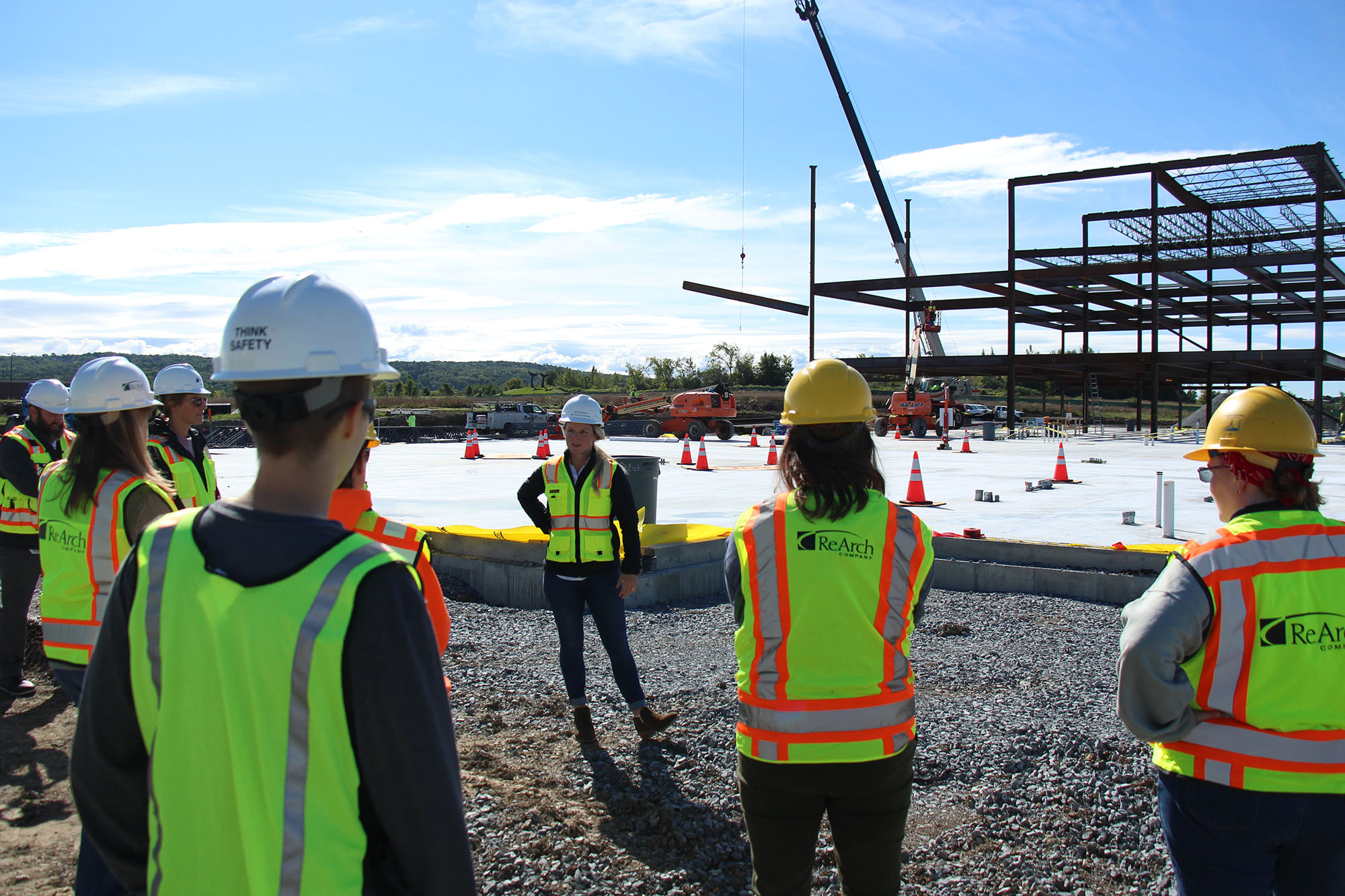 Female employer stands in front of construction site talking to Trailblazers participants.