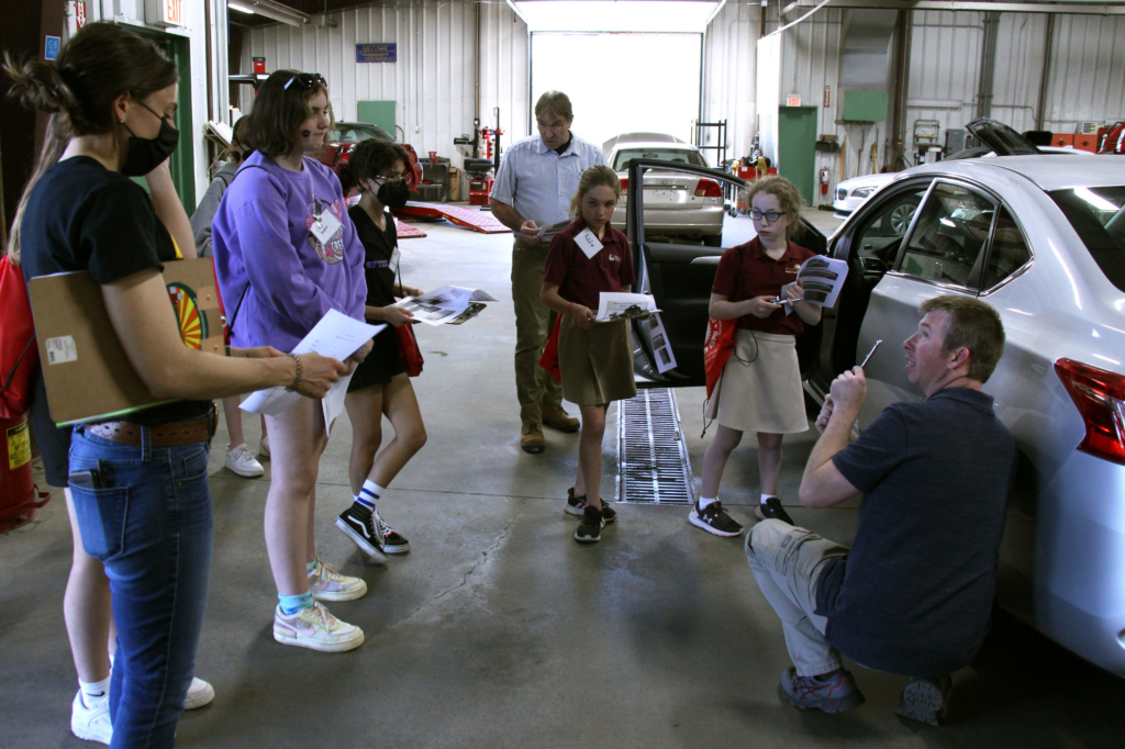 Students learn how to check a car tire's air pressure.