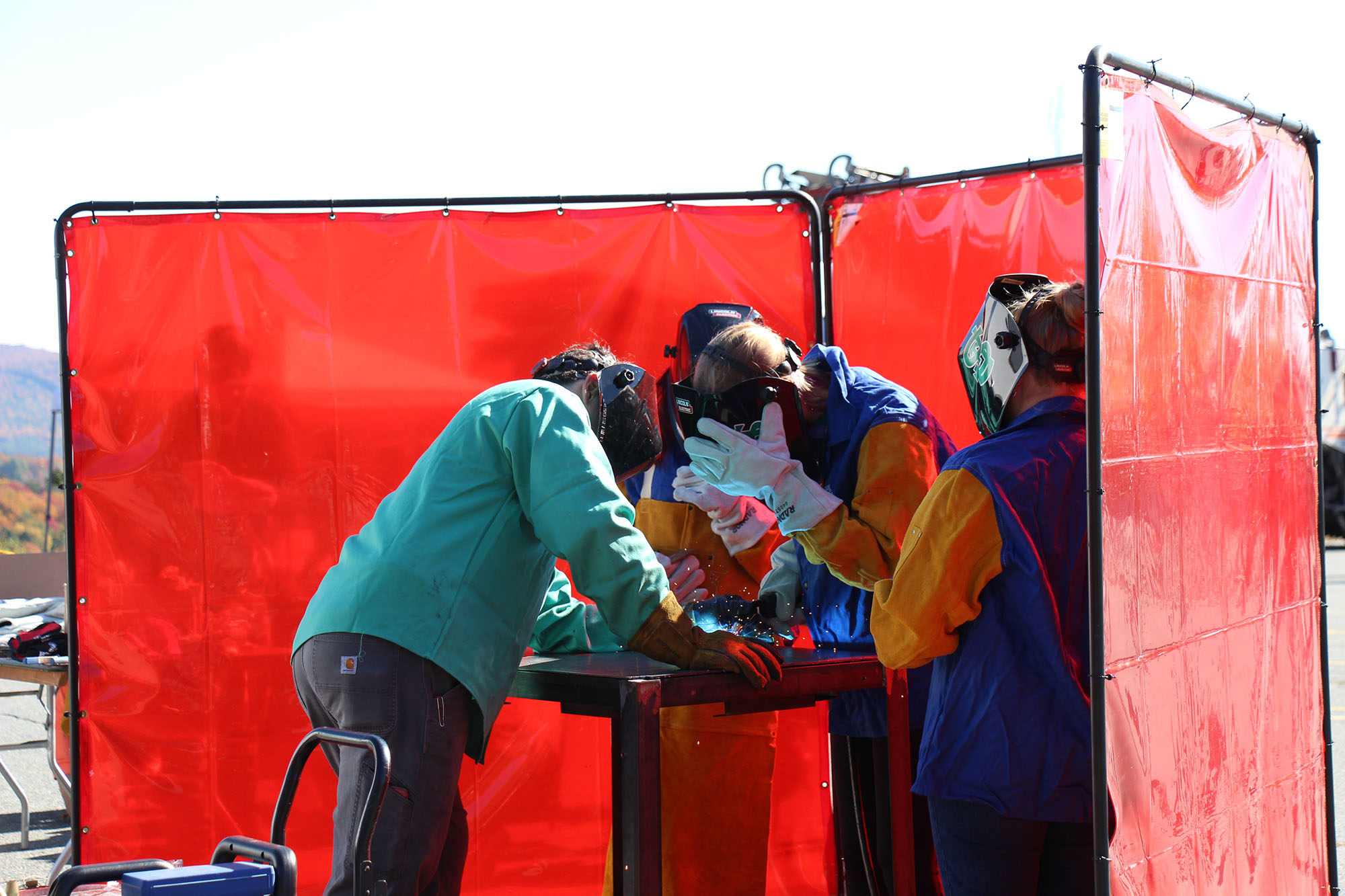Instructor shows students on how to weld at Women Can Do’s Outdoor Action Expo.
