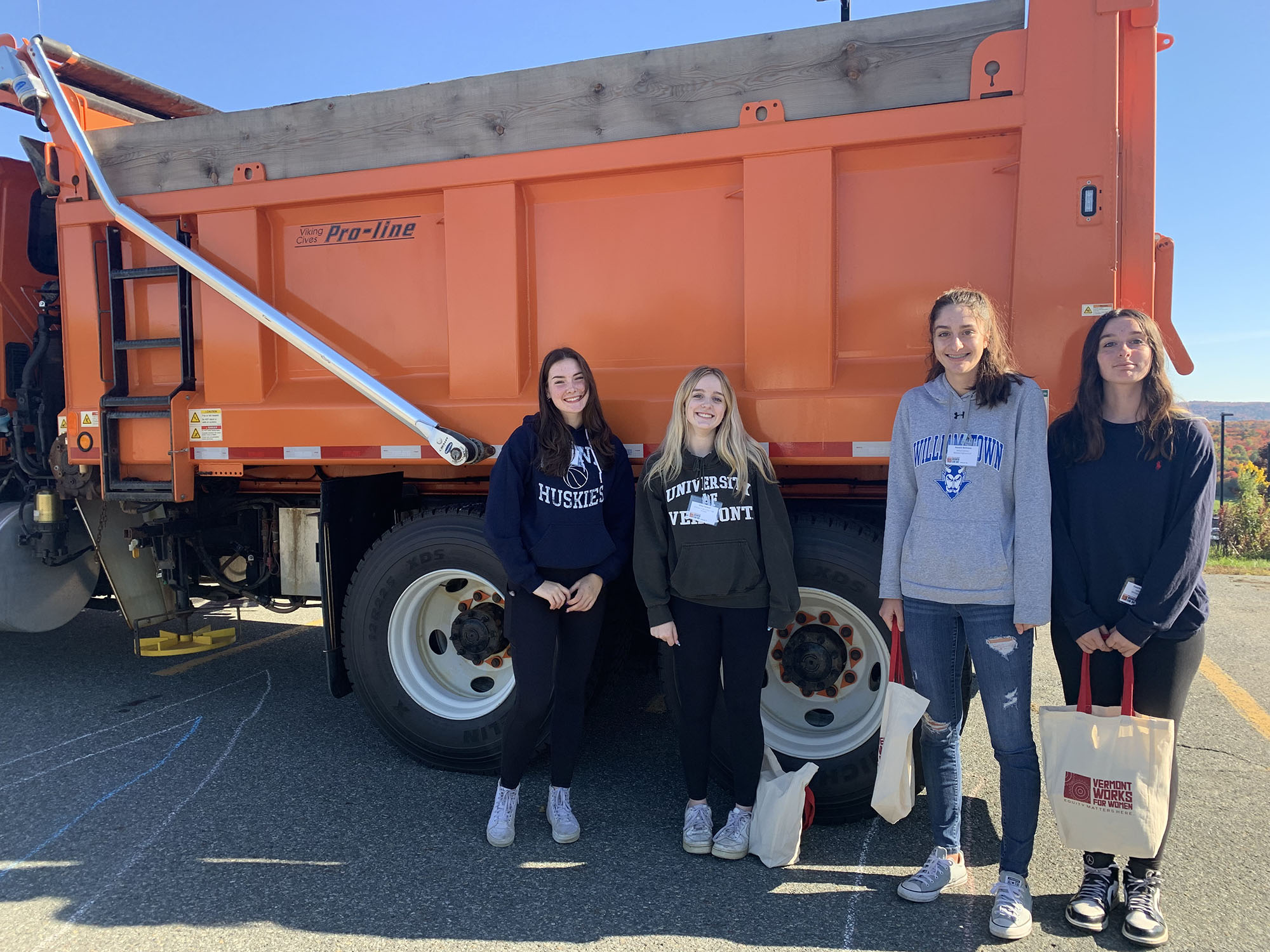 Students pose in front of a dump truck at Women Can Do.