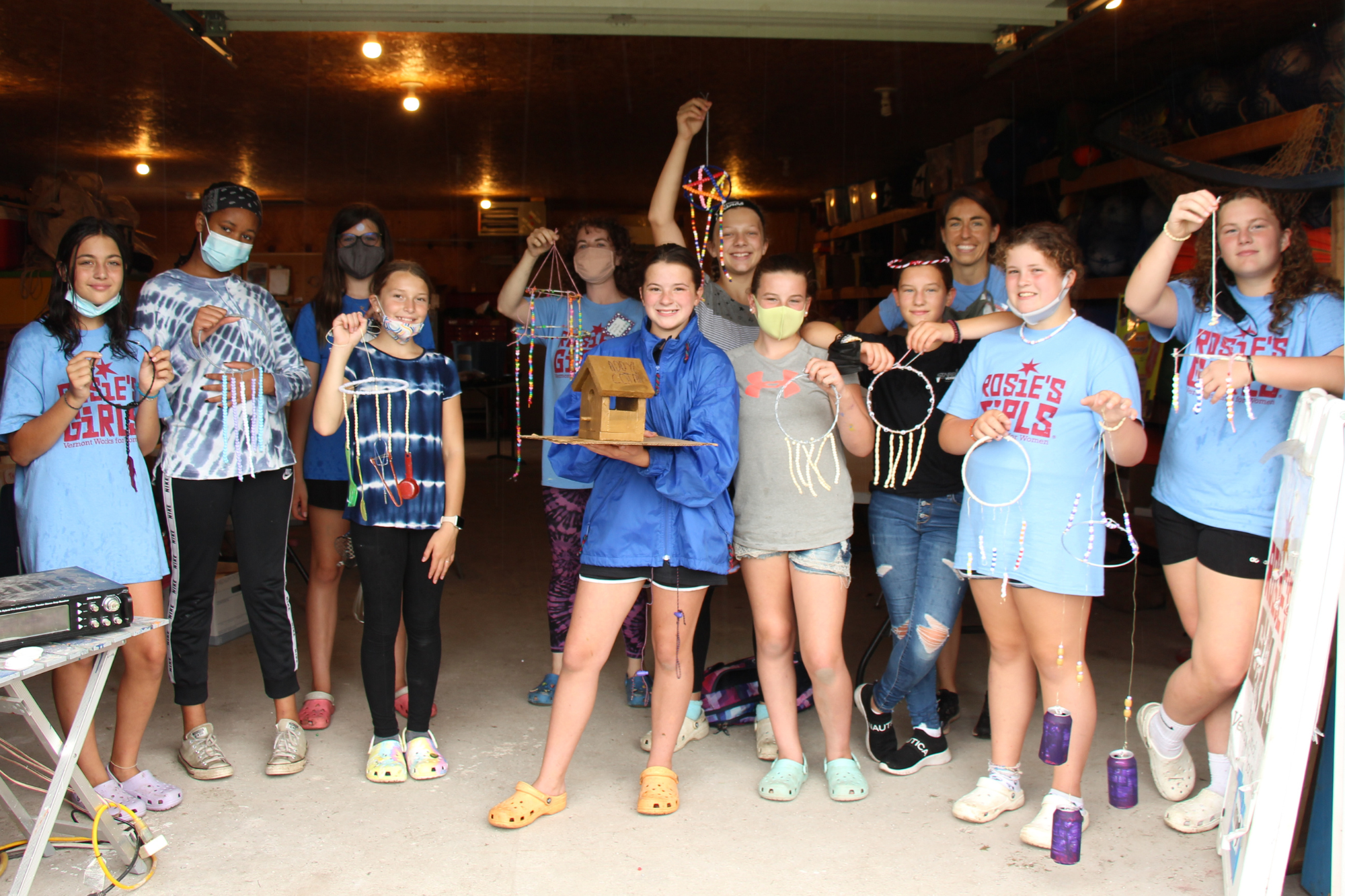 Rosie's Girls campers hold up windchimes and other projects they built.