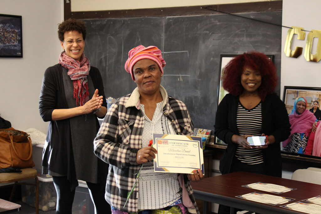 A participant accepts a certificate for completing a digital literacy course with Vermont Works for Women, AALV and Technology 4 Tomorrow.
