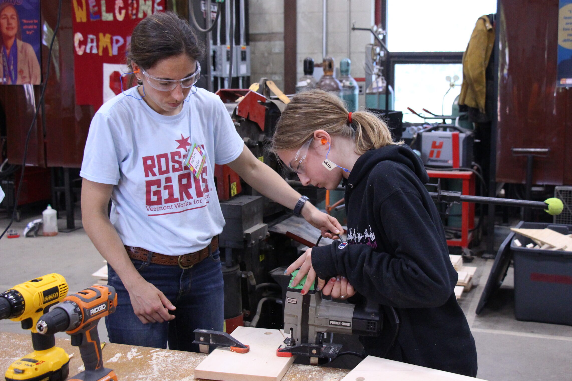 A Rosie's Girls camper uses a jig saw under the supervision of a Vermont Works for Women staff member.