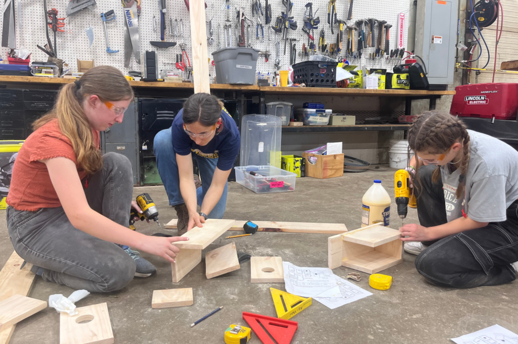 LIFT participants use drills to craft bird houses.