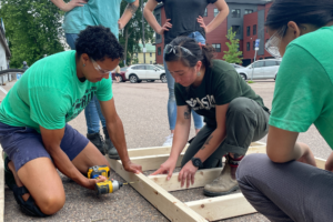 Trailblazers use a drill to construct a new half wall.