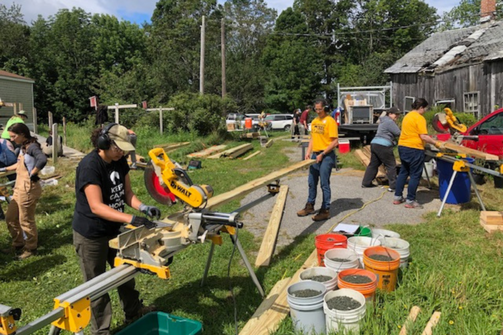 Traiblazers use saws to cut wooden boards.