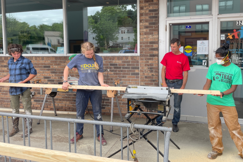 Trailblazers use a saw to cut lumber