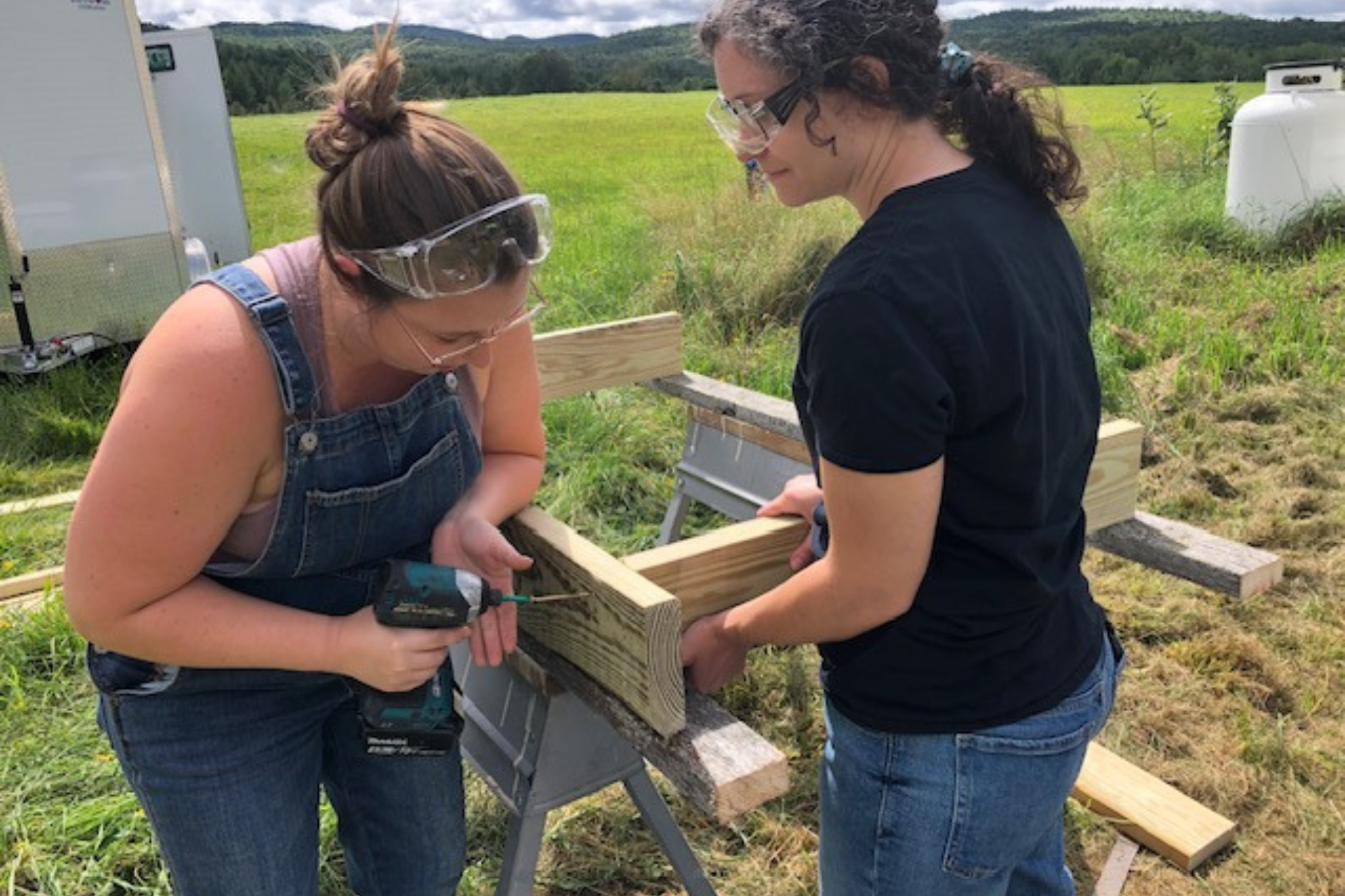 Trailblazers use a drill to drill two pieces of lumber together.