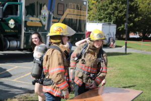Students try on firefighting gear at Women Can Do