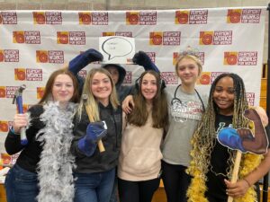 Students pose at photo booth in the Indoor Action Expo at Women Can Do