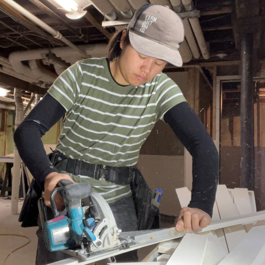 Trailblazers Alumna Sophia uses a saw to cut wood on the jobsite at Montpelier Construction