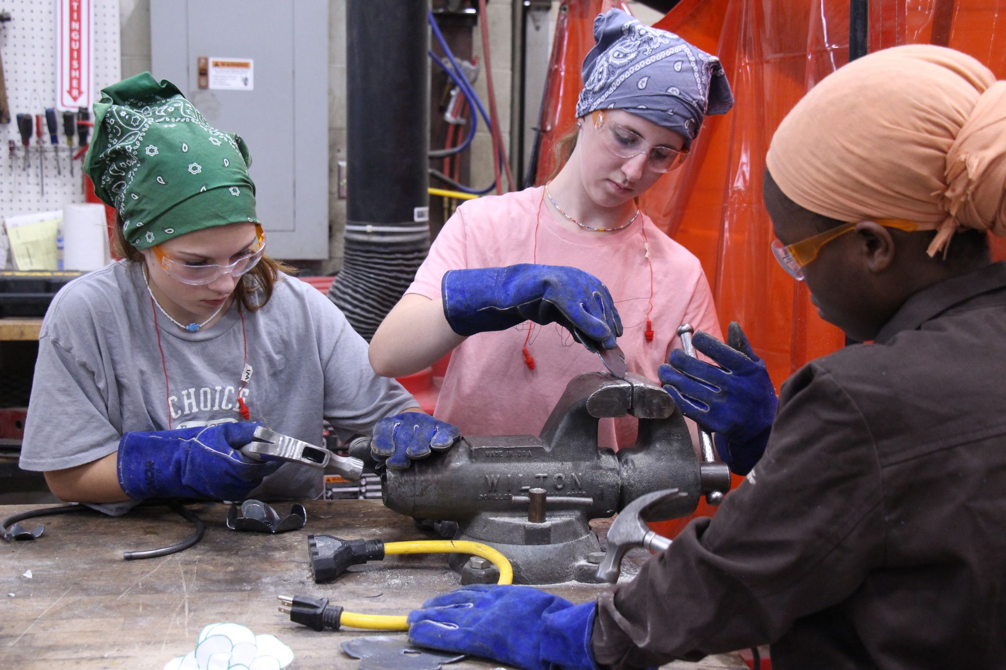 LIFT participants use hammers to shape metal pieces.