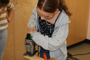 Student uses a jigsaw at Rosie's Girls Afterschool 