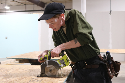 Trailblazers uses a saw to cut plywood.