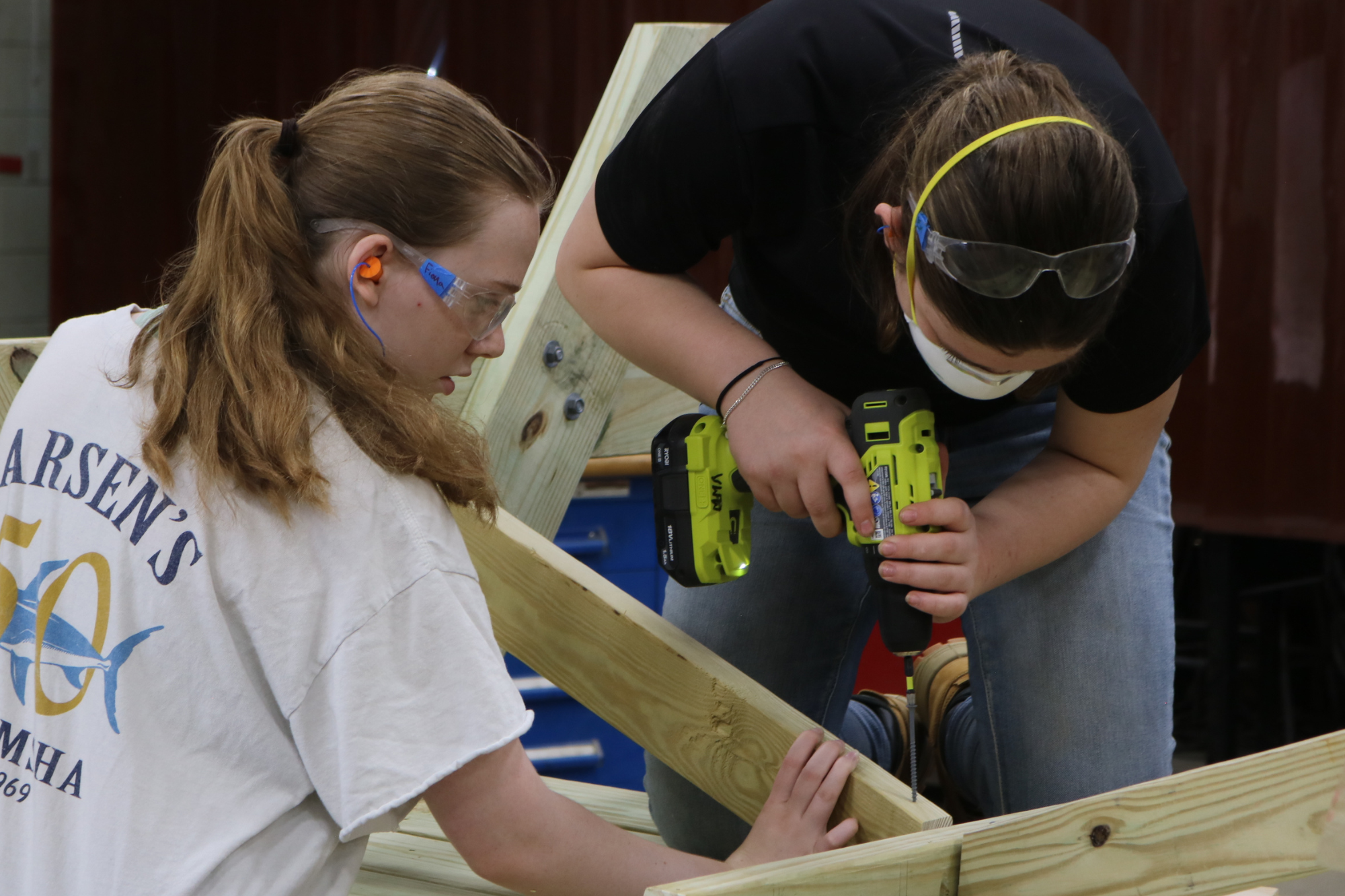 High school girls at LIFT use a drill to make a picnic table during the week-long program for high school girls.