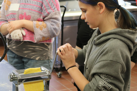 Middle school student tries making pasta at Career Challenge Day.