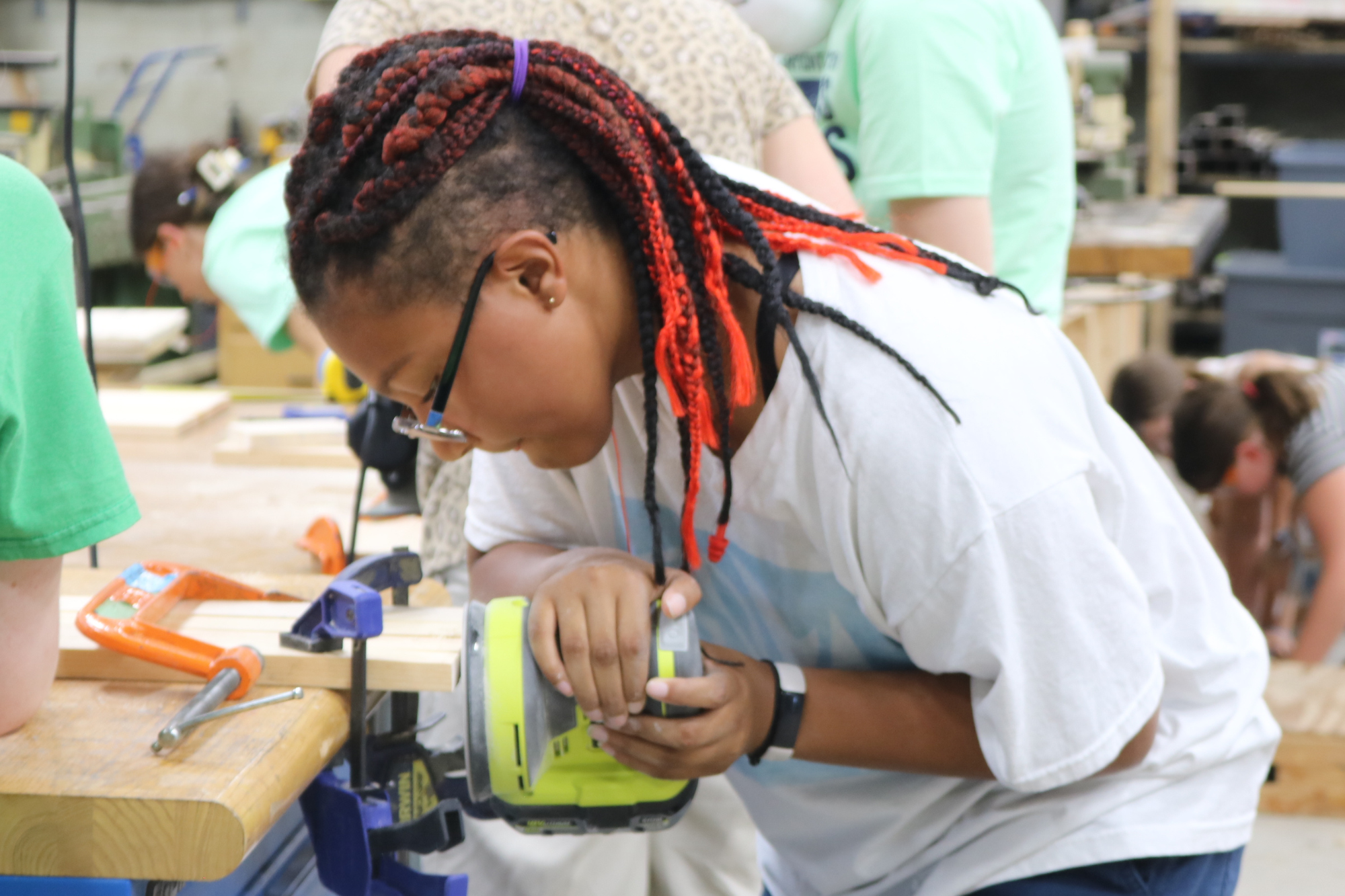 A middle school student uses a sander at Rosie's Girls summer camp.