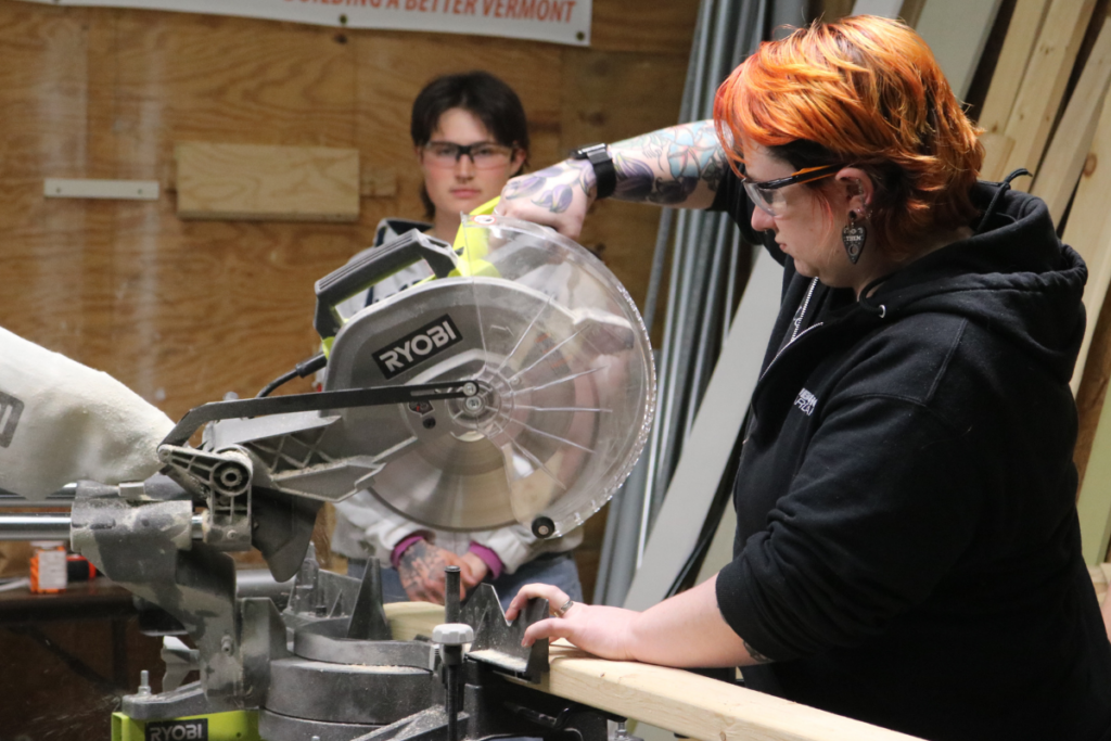 Trailblazer, Leigh, uses a miter saw to cut lumber.