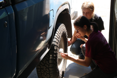 LIFT participant uses a tire gauge to check the air pressure in a tire