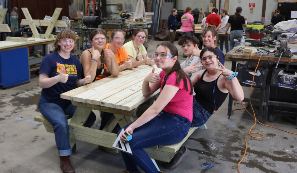 LIFT participants pose with the picnic table they built during the week-long summer program.