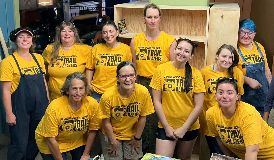 Brattleboro Trailblazers pose in front of shelves they built