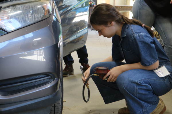 Bri checks a car's tire pressure during LIFT.