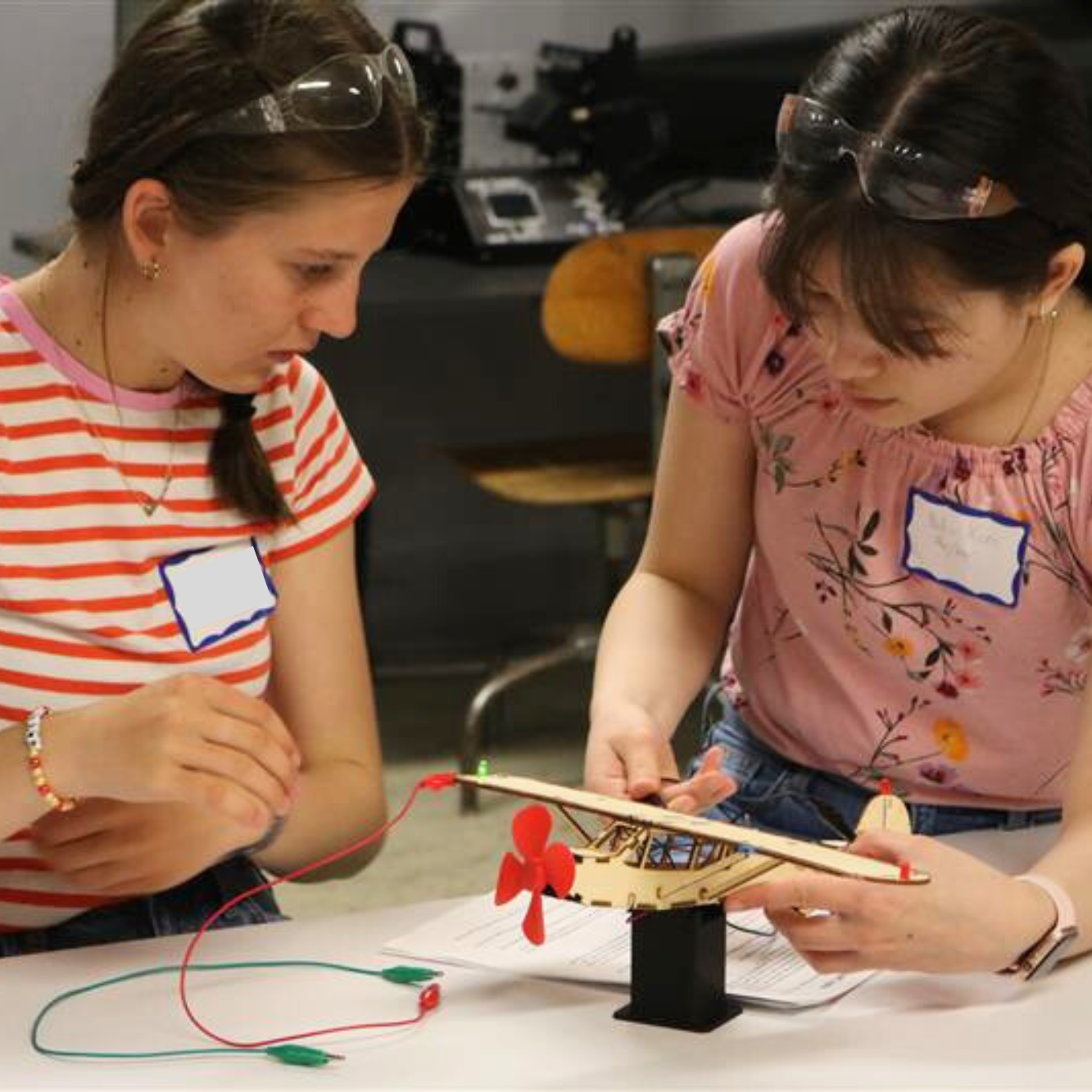 Middle school girls use wires and circuits to make a propeller run on a wooden model plane. Introducing girls to a variety of career opportunities is part of Vermont Works for Women's overall mission.