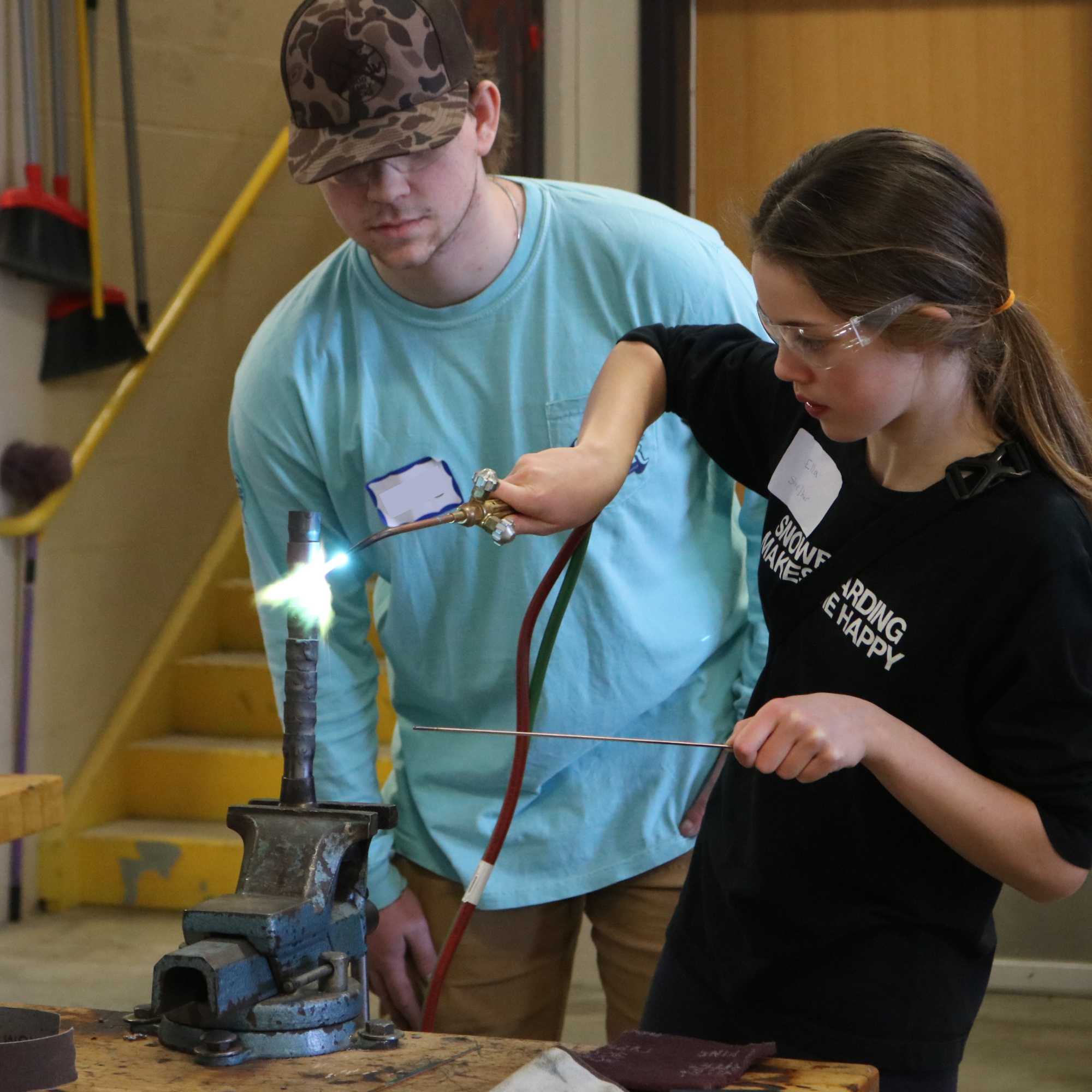 A middle school student solders a metal pipe at Career Challenge Day.