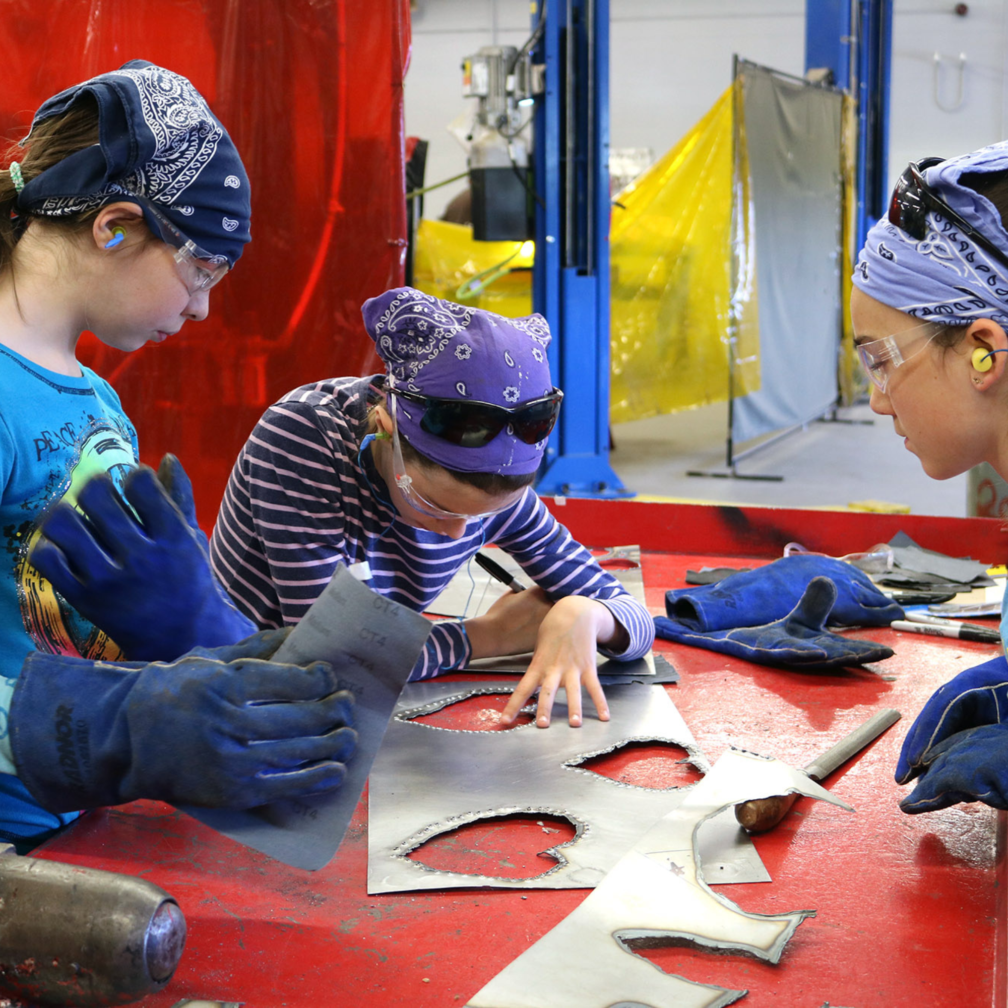 Rosie's Girls campers design and plan projects using sheet metal at Rosie's Girls WELD summer camp for middle school girls.