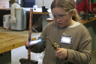 Middle school girls solders at Career Challenge Day at GMTCC