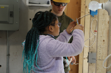 A middle school girl learns how to wire an outlet at Career Challenge Day at GMTCC