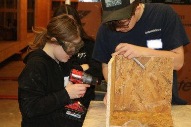 Middle school girl uses a drill to build a box at Career Challenge Day at GMTCC