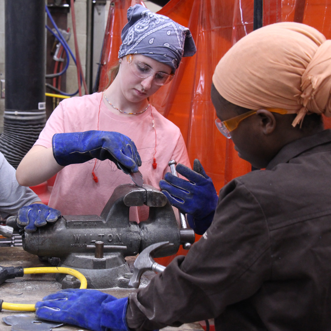 High school girls use hand tools to shape metal during LIFT.