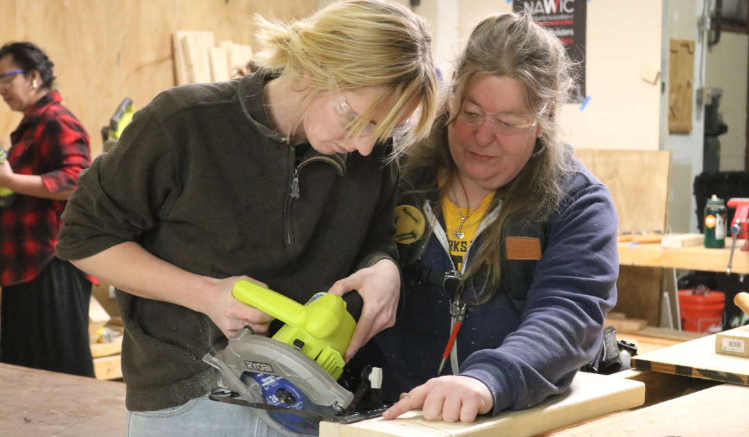 Trailblazers participant uses a saw with the help of an instructor